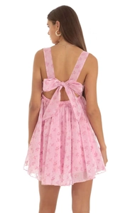 Detail of pink floral mini dress showing open back design and large decorative bow
