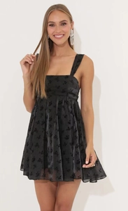 Detail of black floral jacquard mini dress with square neck and satin texture