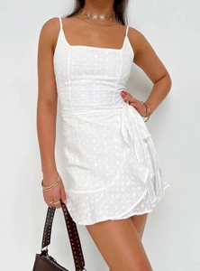 Close-up of white floral embroidery and cutout lace details on summer sundress