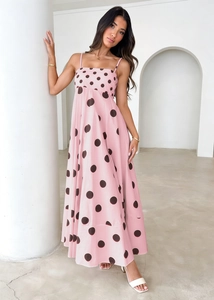 Detail of pink summer maxi dress featuring black polka dots and thin shoulder straps