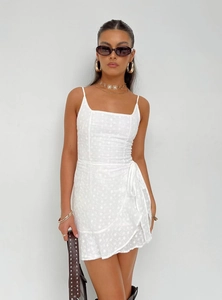 Close-up of white spaghetti strap mini dress with intricate floral eyelet embroidery detail