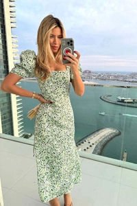 Detail of puff sleeves and green floral print on a French style midi dress