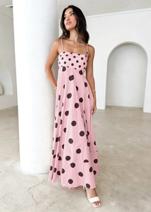 Close-up of pink polka dot maxi dress with high waist design and lightweight fabric texture