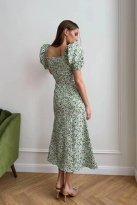 Side view of floral maxi dress with puff sleeves and back tailoring in elegant interior