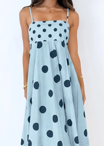 Detailed close-up of light blue polka dot sundress featuring thin straps and waist pleats