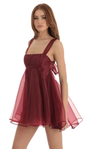 Close-up of deep red sleeveless babydoll dress with square neck and back bow detail