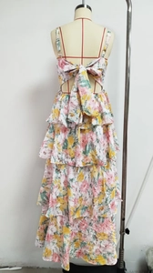Detail of multi-tier floral summer dress with a large decorative back bow and pleated layers