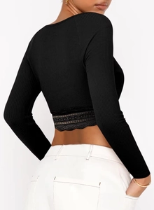 Détail d'un crop top noir montrant l'ourlet en dentelle et la texture en maille fine