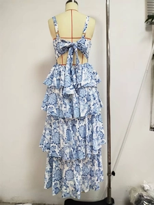 Detail of blue floral tiered maxi dress featuring an open back and oversized bow tie closure