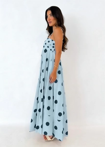 Detail shot of light blue polka dot sundress featuring thin straps and flowing hemline