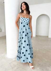 Detail view of light blue maxi dress with bold dark polka dots and thin spaghetti straps