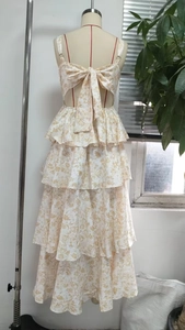 Detail showing the tiered floral dress back with a large bow tie and cutout design