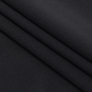 Détail du tissu noir d'une robe en dentelle avec texture mate et bel effet de drapé