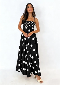 Detailed full view of black polka dot sundress with slim straps and flowing A-line skirt