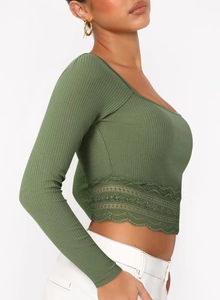 Détail du crop top vert olive côtelé à manches longues avec bordure en dentelle