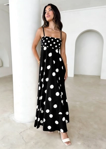 Detail of black polka dot maxi dress with thin spaghetti straps and elegant square neckline