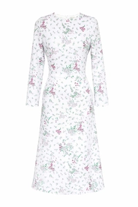 Detail of floral print pattern on white long sleeve dress with pink flower accents