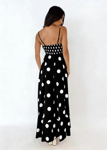 Back view of a black and white polka dot camisole maxi dress with an elastic waist detail