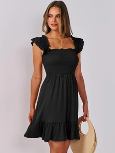 Detail of black mini dress featuring smocked bodice and ruffled cap sleeves