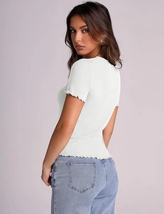 Detail of white ribbed knit t-shirt featuring sweet lettuce edge trim on the sleeves and hem