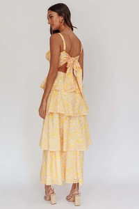 Detail of yellow floral two-piece set featuring back bow-tie and tiered maxi skirt layers