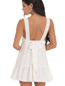 White sleeveless backless mini dress with large bow tie and ruffled hem details