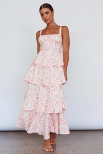 Detail view of the layered tiered hem and floral print on white sleeveless maxi dress