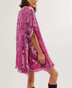 Detail of retro purple floral velvet dress showing soft texture and ruffle hemline