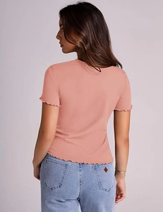 Detail view of the pink ribbed knit texture and stylish lettuce hem on a slim T-shirt