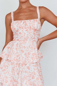 Detailed view of floral print dress featuring square neckline and layered peplum waist