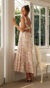 Close-up of a floral maxi dress featuring a backless cross-strap design and tiered skirt