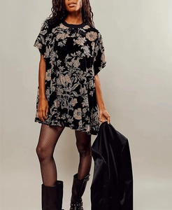 Detail view of vintage black velvet mini dress featuring intricate floral pattern and textures