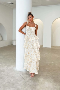 Detail of white tiered maxi dress with yellow floral pattern and bow shoulder straps