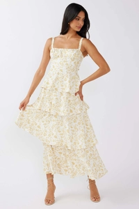 Close-up of tiered ruffle hem and yellow floral print on white summer maxi dress