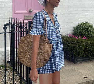 Détail d'un ensemble d'été à carreaux bleus avec manches évasées et sac en paille brodé