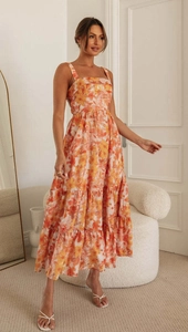 Detailed view of floral pattern and layered ruffled hem on orange summer maxi dress