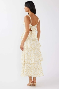 Detailed back view of yellow floral tiered dress featuring a bow tie and open back design