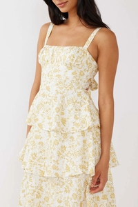 Detail of white floral tiered dress featuring yellow prints and a rear bow tie accent