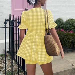 Détail d'un ensemble à carreaux jaune et blanc avec manches à volants et taille haute