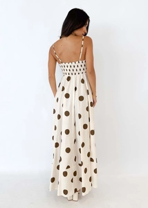 Detail view of the elastic shirred back and thin straps on a polka dot maxi dress
