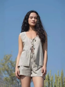Chic beige plaid two-piece set featuring sleeveless tie-up top and elastic waist shorts