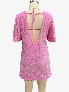 Detail of pink sequin velvet dress featuring an elegant backless V-neck design with ties