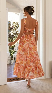 Detail of summer tiered maxi dress featuring criss-cross back straps and orange floral print