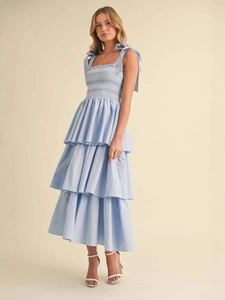 Light blue tiered smocked midi dress with adjustable bow shoulder straps and ruffles