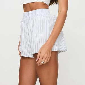 Détail d'un short d'été taille haute pour femme avec rayures verticales noires sur blanc