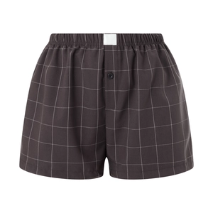 Detail of grey plaid boxer shorts showing elastic waistband and button fly closure