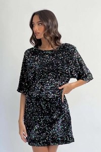 Close-up of sparkling sequin fabric on black cocktail dress with iridescent metallic shine