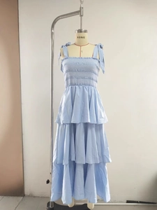 Light blue tiered summer dress with smocked bodice and tie-straps on female mannequin