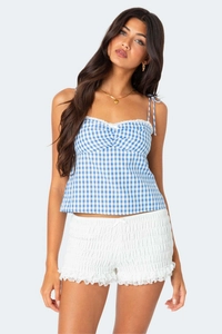 Close-up of blue gingham camisole with white lace trim and adjustable bow straps