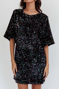 Detailed close-up of shiny multicolored sequins on a black velvet party dress fabric